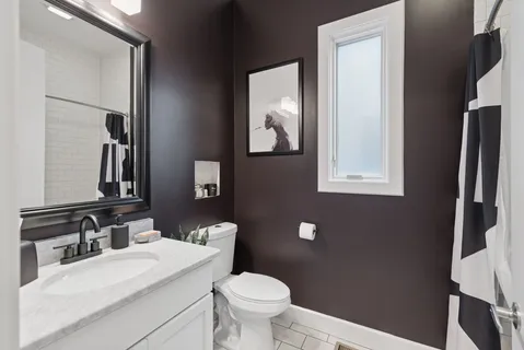 a bathroom with a toilet a sink a vanity and mirror