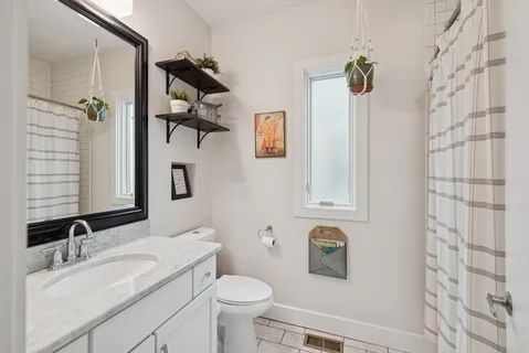 a bathroom with a sink vanity mirror and toilet
