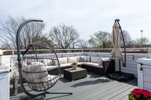 a roof deck with couches and wooden floor
