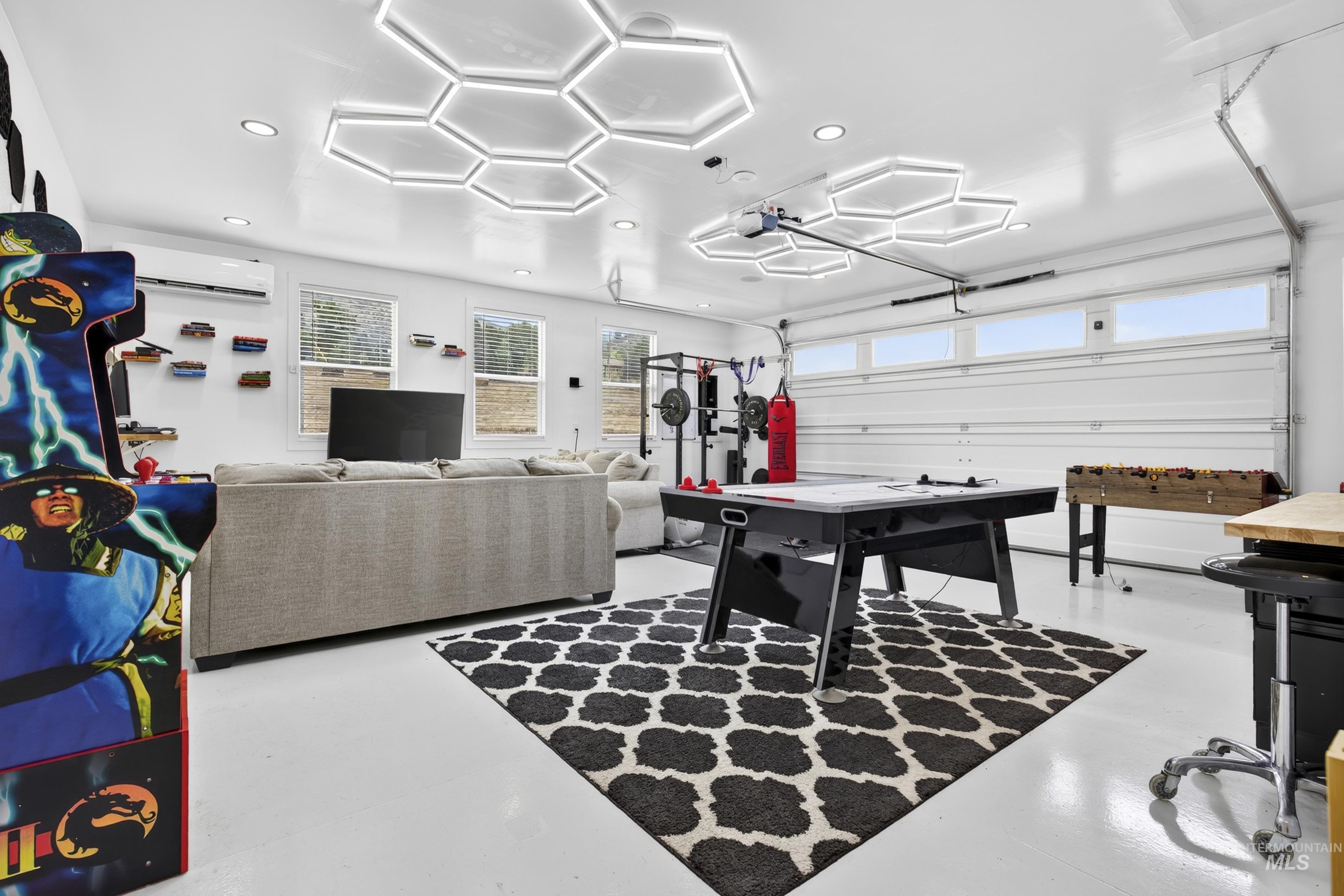 132 Mores Creek Rim Road Boise, ID 83716 - Photo 35 of 44 White epoxy flooring, modern hexagonal ceiling lighting, multiple windows with blinds, a white garage door with upper window panels, and a built-in air conditioning unit