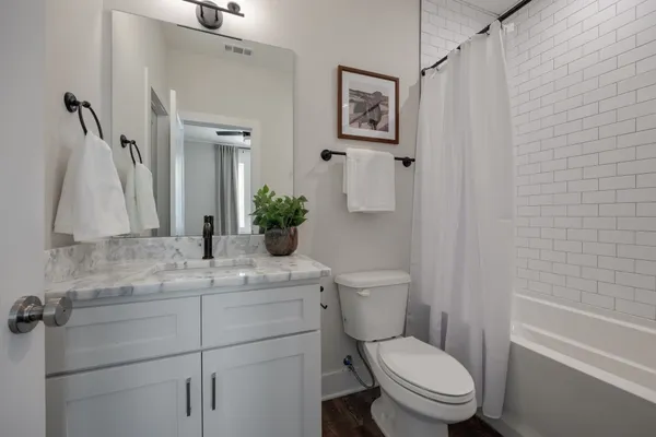 a bathroom with a granite countertop toilet sink and mirror