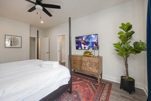 a bedroom with a bed potted plant on the dresser and a table