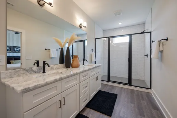 a bathroom with a granite countertop sink mirror and shower