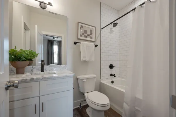 a bathroom with a sink toilet a mirror and shower