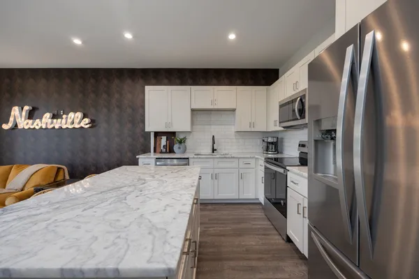 a kitchen with stainless steel appliances granite countertop a refrigerator sink and stove