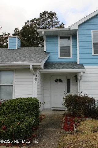 a front view of a house with plants