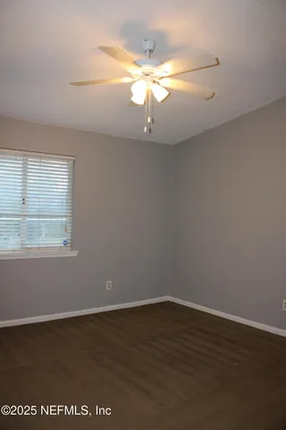 a view of a room with wooden floor and chandelier fan
