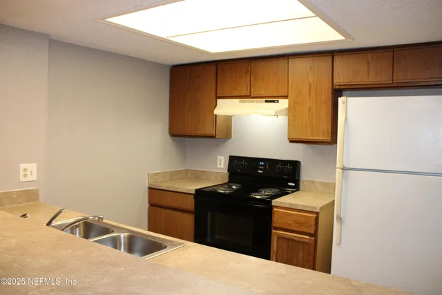 a kitchen with a refrigerator and a sink