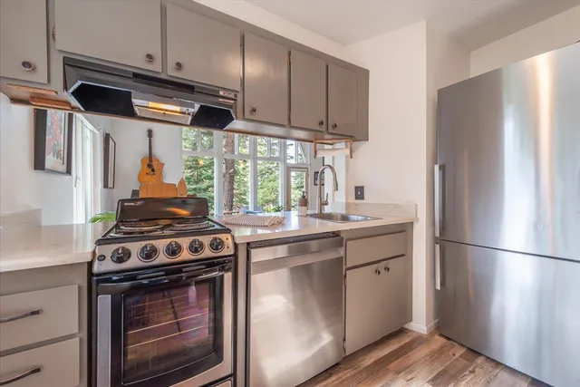 a kitchen with stainless steel appliances granite countertop a stove a refrigerator and a stove