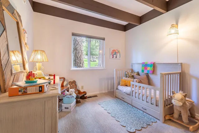 a bedroom with furniture a rug toys and a window