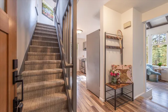a view of a hallway with wooden floor and windows