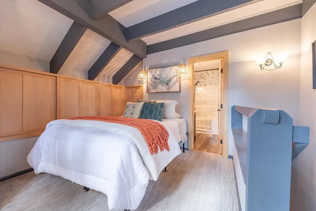 a bed sitting in a bedroom next to a window