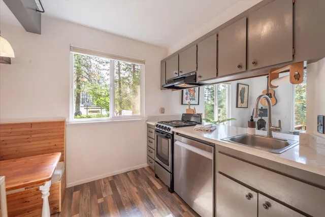 a kitchen with stainless steel appliances granite countertop a sink a stove and cabinets