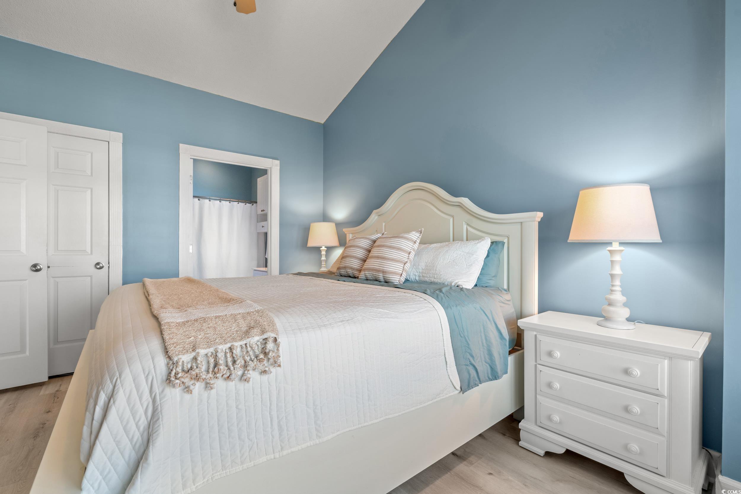 4864 Carnation Circle, Unit 304 Myrtle Beach, SC 29577 - Photo 15 of 36 Bedroom featuring light wood-type flooring, vaulted ceiling, ceiling fan, and ensuite bath
