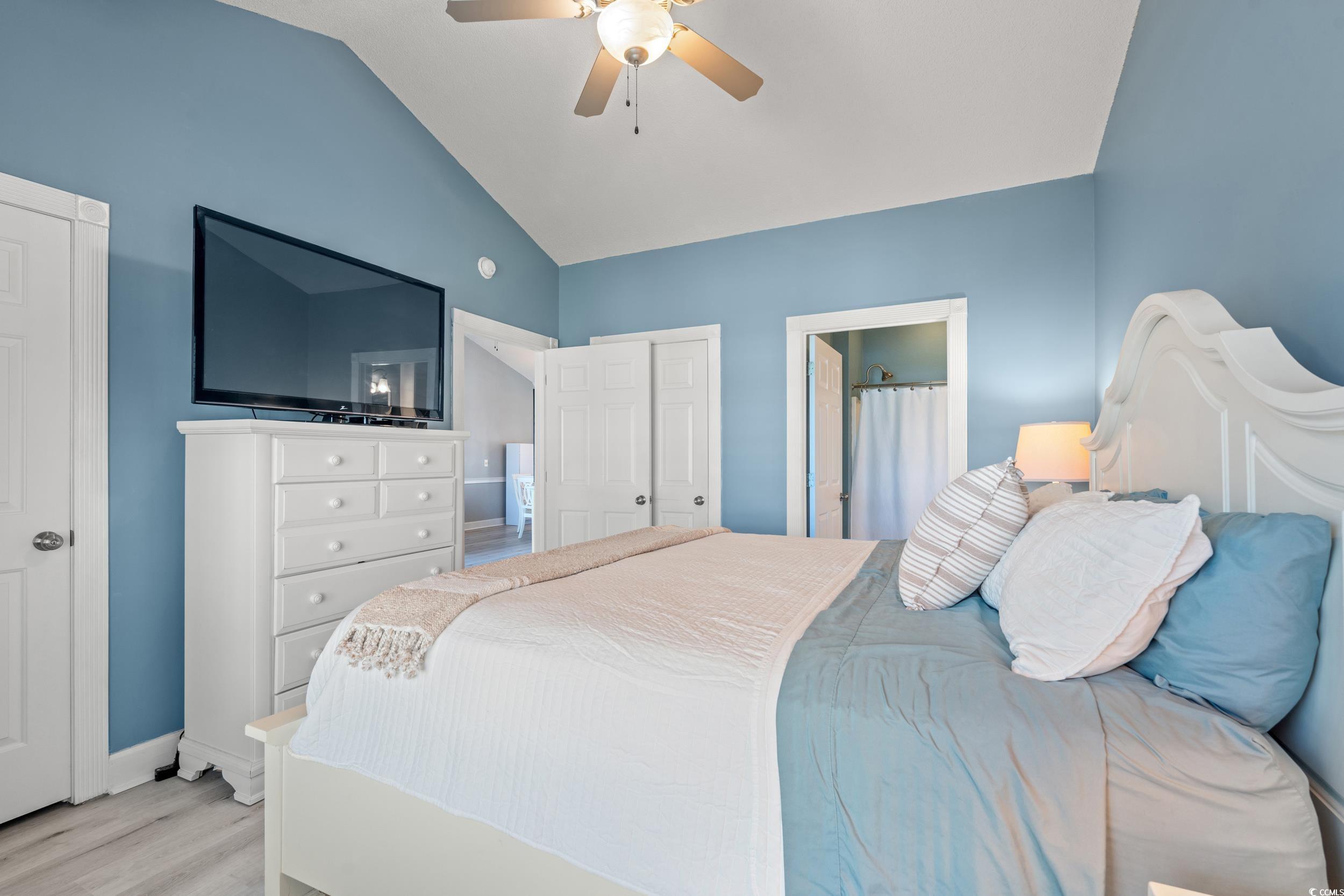 4864 Carnation Circle, Unit 304 Myrtle Beach, SC 29577 - Photo 17 of 36 Bedroom featuring vaulted ceiling, wood finished floors, ceiling fan, ensuite bath, and a closet