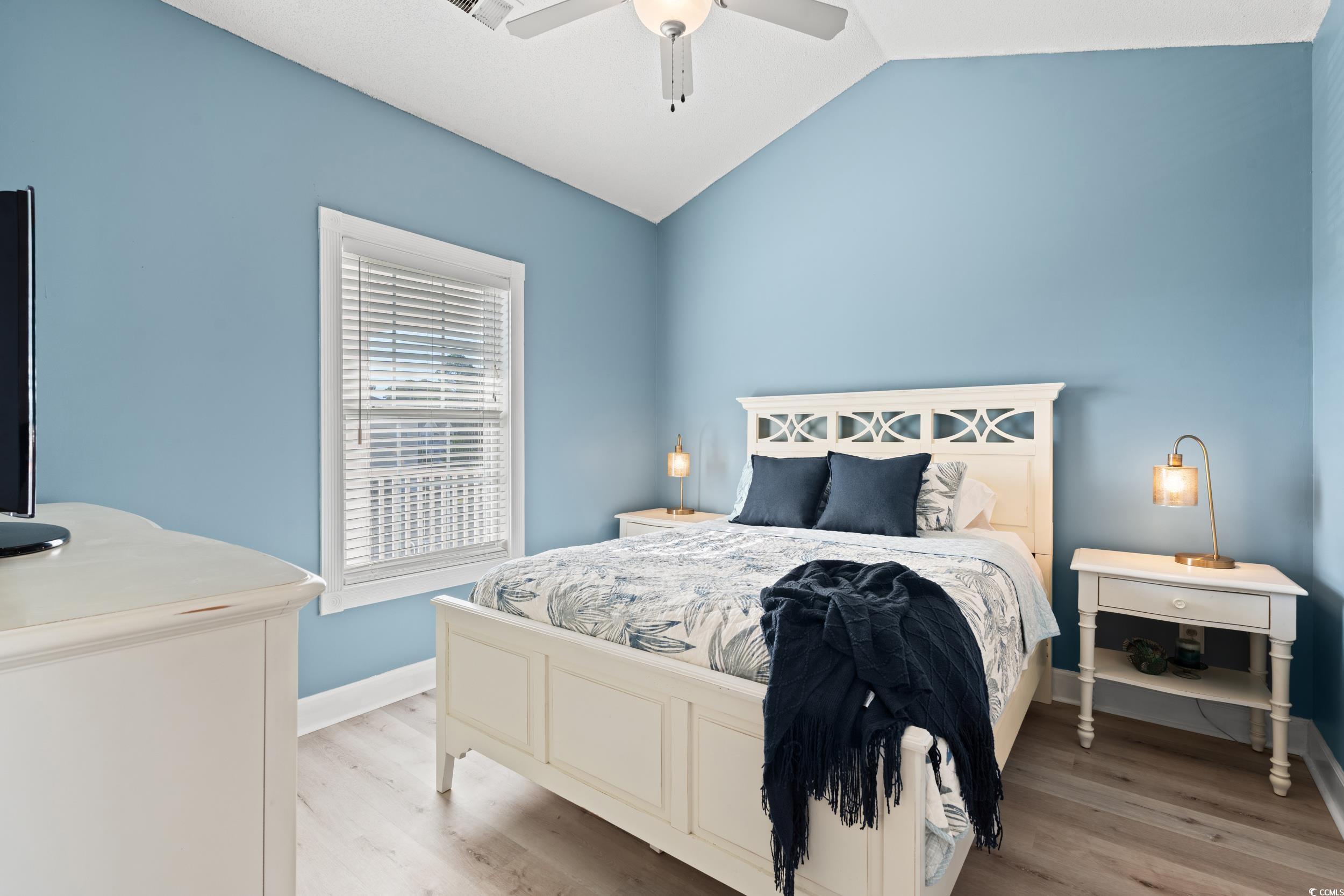 4864 Carnation Circle, Unit 304 Myrtle Beach, SC 29577 - Photo 18 of 36 Bedroom with lofted ceiling, light wood-type flooring, and a ceiling fan