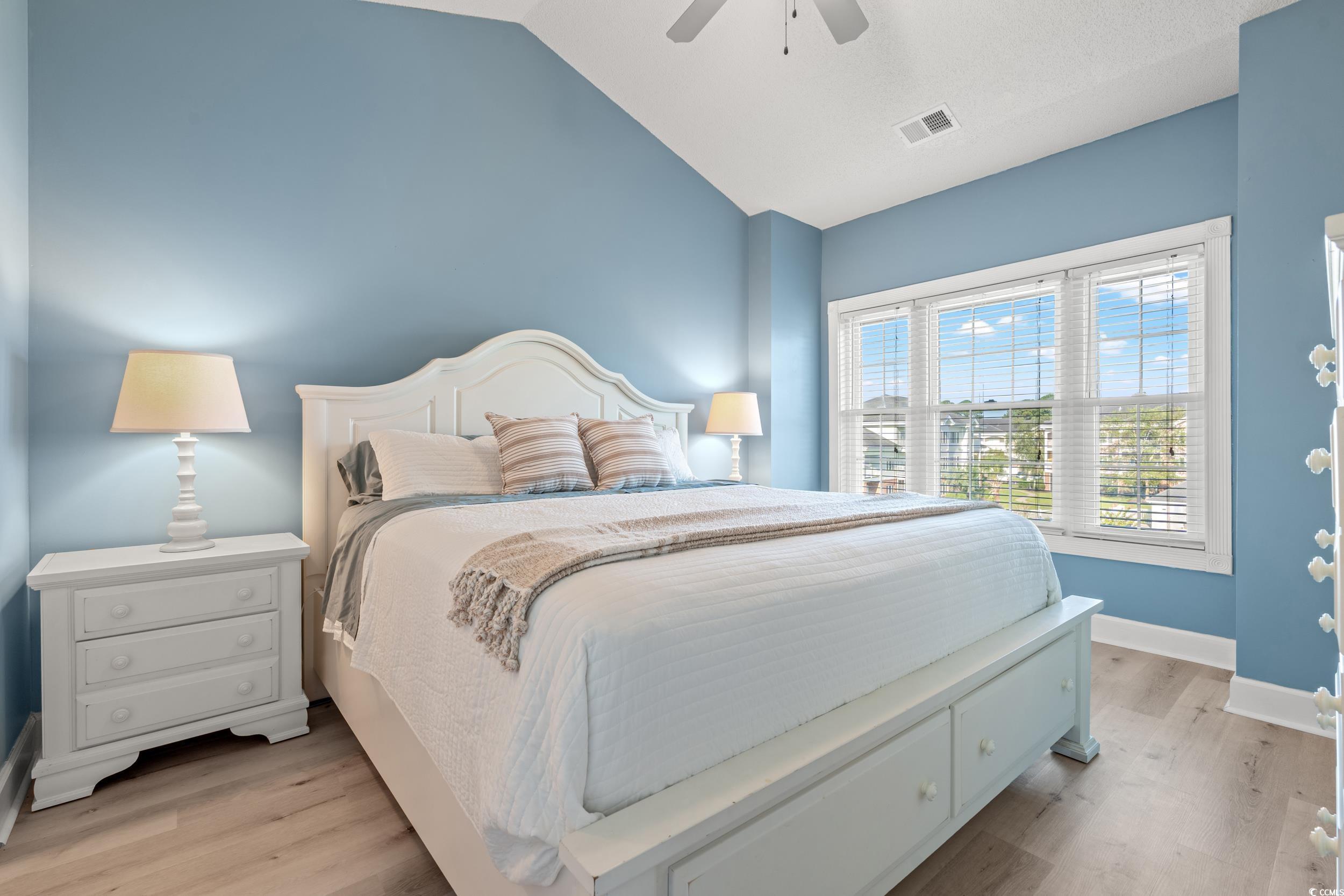 4864 Carnation Circle, Unit 304 Myrtle Beach, SC 29577 - Photo 2 of 36 Bedroom with light wood-style flooring, a ceiling fan, and vaulted ceiling