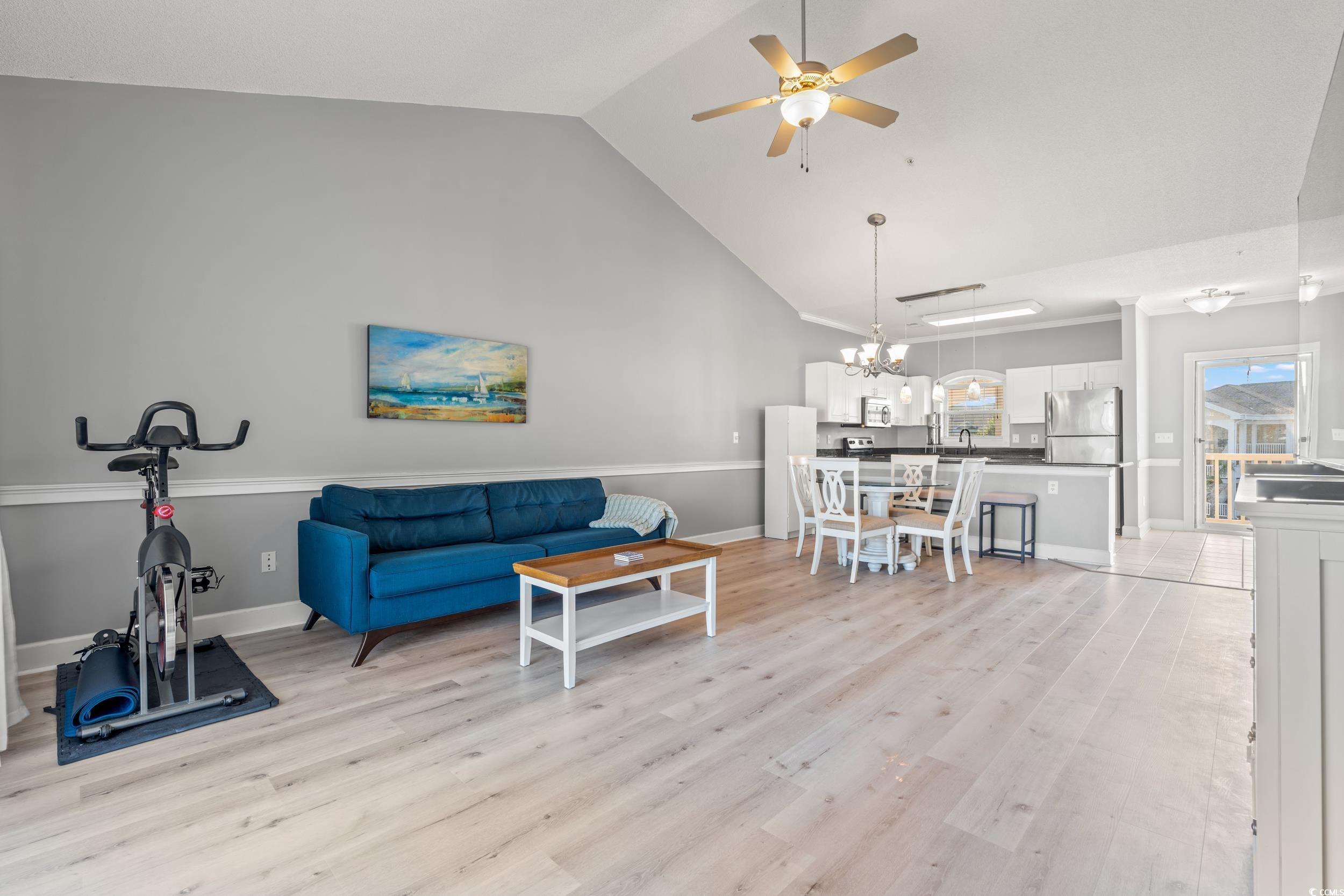 4864 Carnation Circle, Unit 304 Myrtle Beach, SC 29577 - Photo 7 of 36 Living area with high vaulted ceiling, light wood finished floors, a ceiling fan, and a chandelier