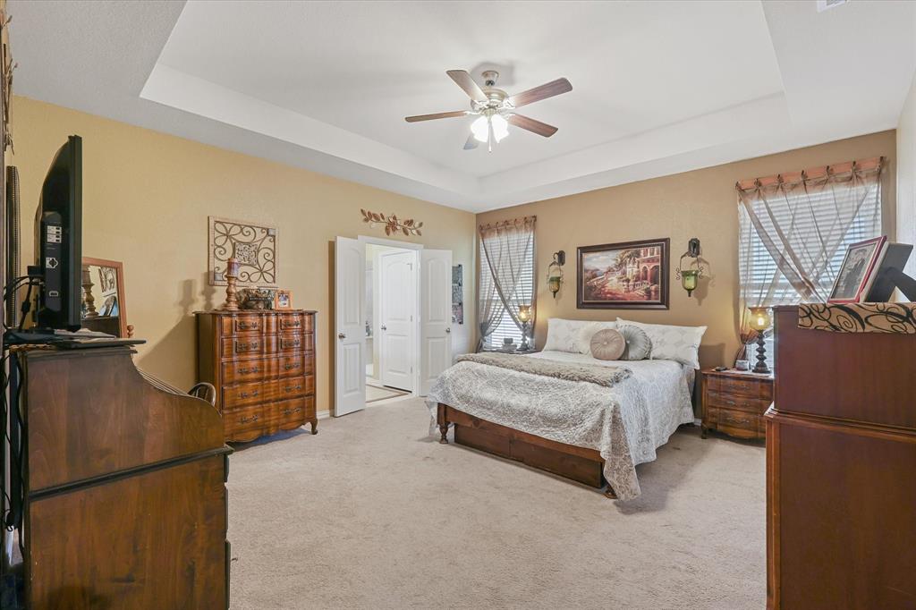 2375 County Road 4010 Decatur, TX 76234 - Photo 13 of 34 Bedroom with a raised ceiling, light carpet, and ceiling fan