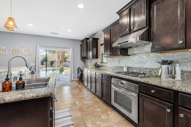 a large kitchen with stainless steel appliances kitchen island granite countertop a sink and cabinets