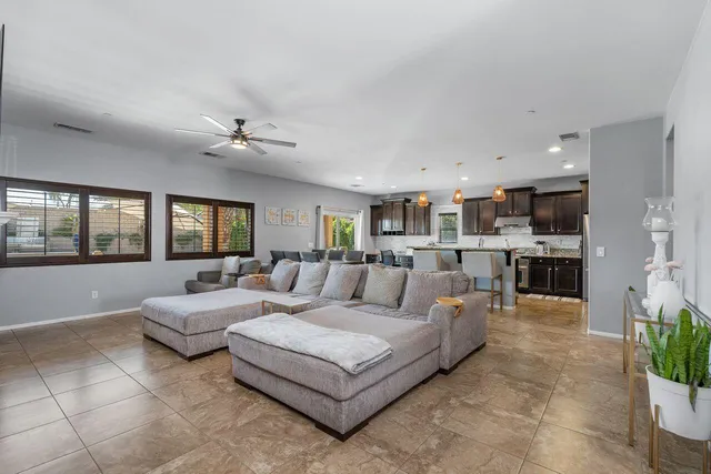 a living room with furniture kitchen view and a window