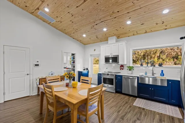 a large kitchen with stainless steel appliances wooden floors and wooden cabinets