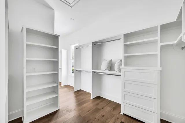 a view of walk in closet with wooden floor