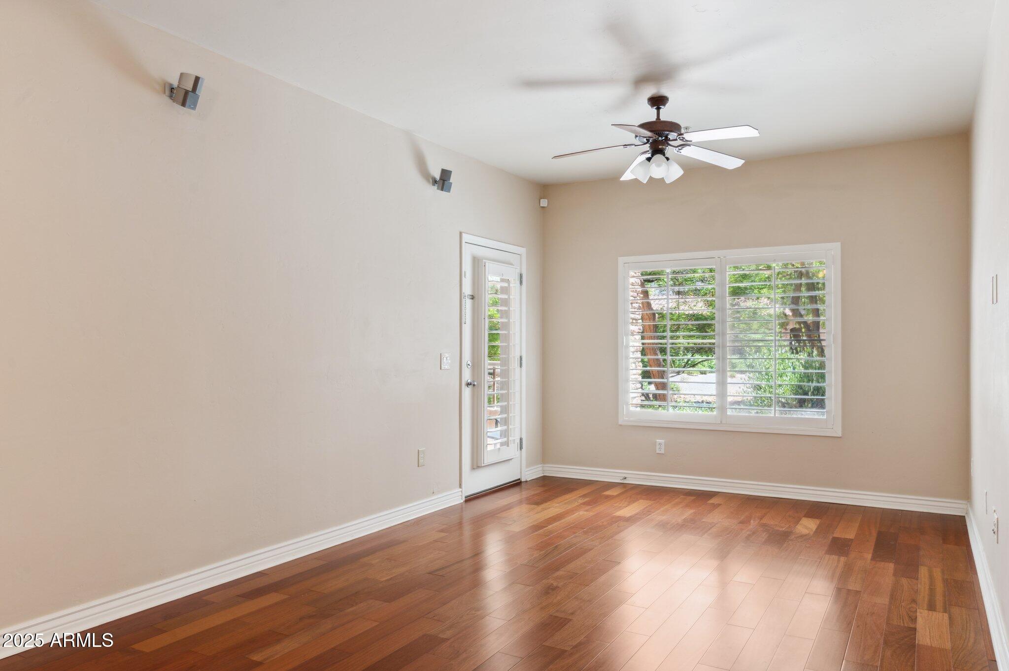 5450 East Deer Valley Drive, Unit 1214 Phoenix, AZ 85054 - Photo 6 of 35 a view of an empty room with wooden floor and a window