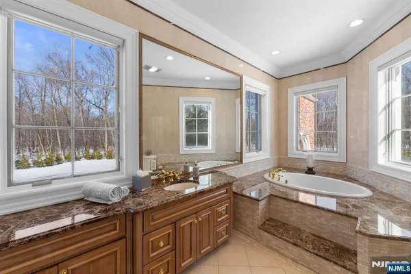 a bathroom with a granite countertop sink and large windows