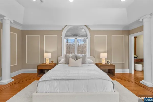 a bedroom with a large bed and a chandelier