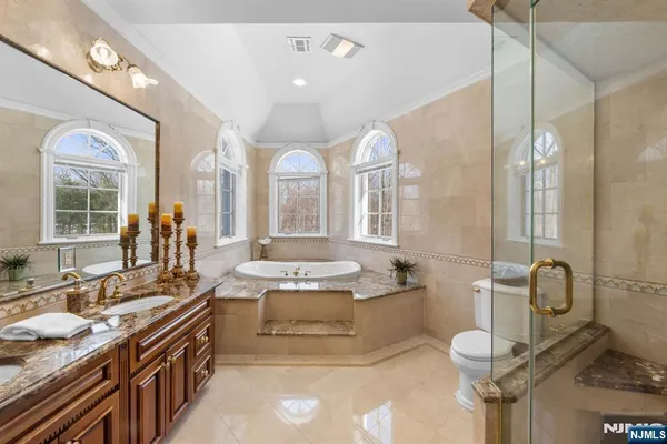 a bathroom with a granite countertop sink a large mirror and a bathtub