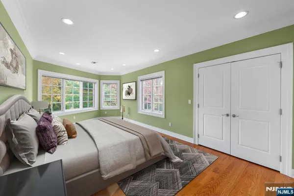 a bed sitting in a spacious bedroom next to a window