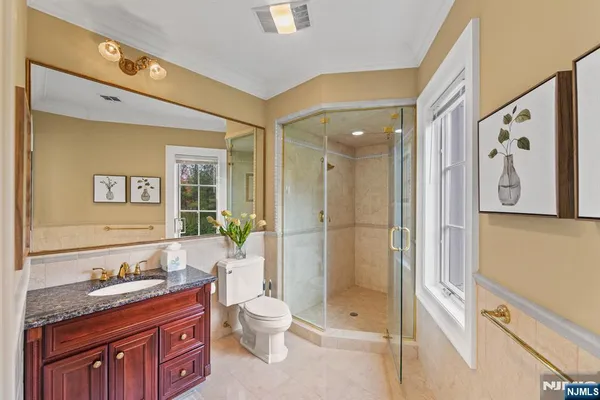 a spacious bathroom with a granite countertop sink toilet and shower