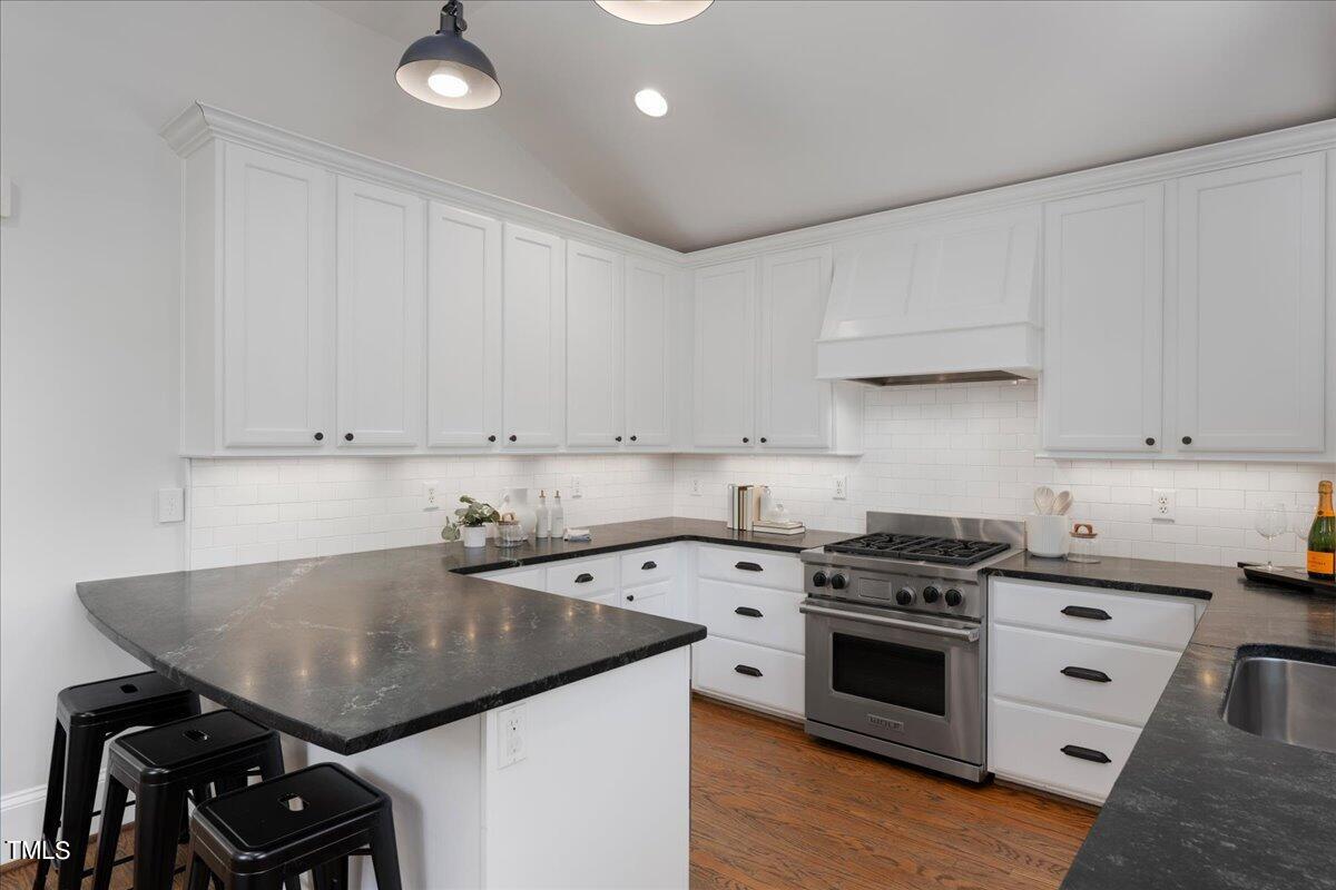 600 Harding Street Raleigh, NC 27604 - Photo 14 of 33 a kitchen with a sink a stove and cabinets