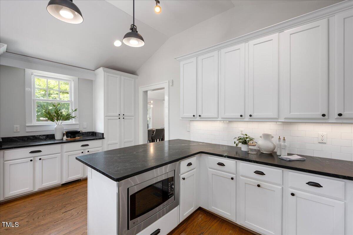 600 Harding Street Raleigh, NC 27604 - Photo 15 of 33 a kitchen with granite countertop white cabinets white appliances a sink and a window