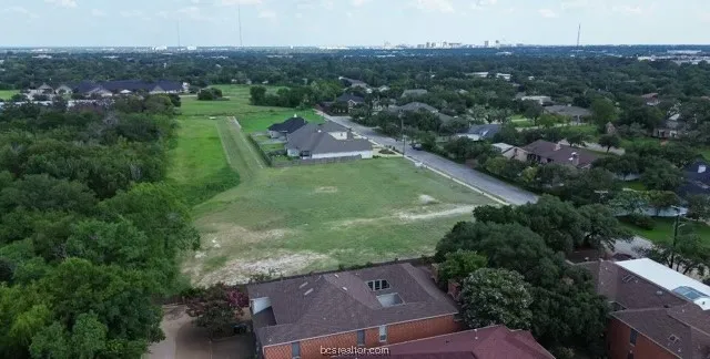 an aerial view of residential houses with outdoor space and trees