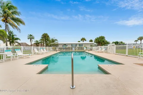 a view of swimming pool with lawn chairs and a yard