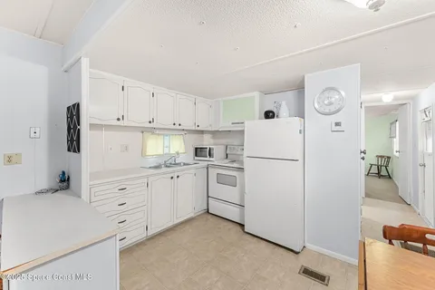a kitchen with a stove a refrigerator and a dining table