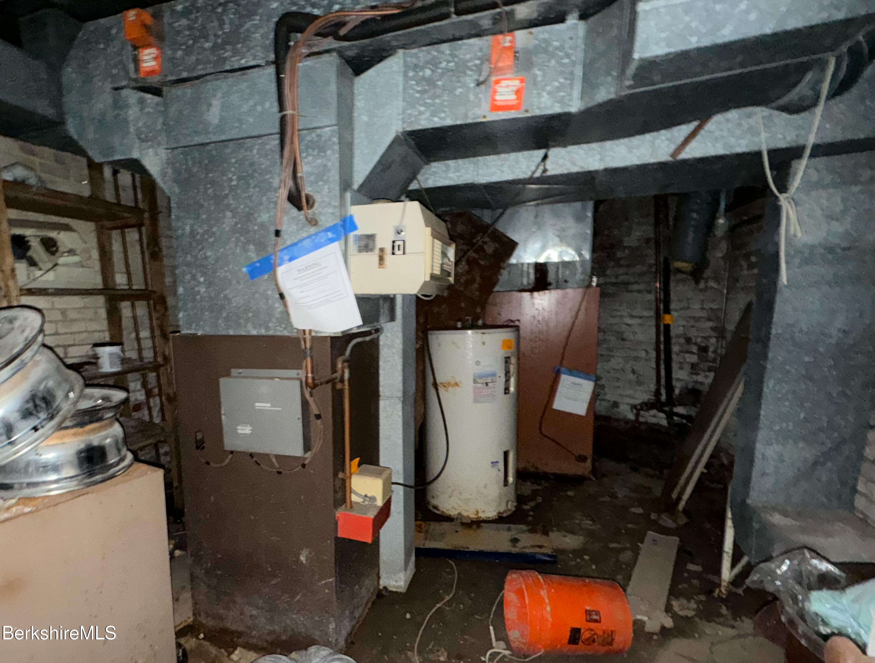 223 Elm Street Holyoke, MA 01040 - Photo 28 of 30 a room with water heater and wooden cabinets