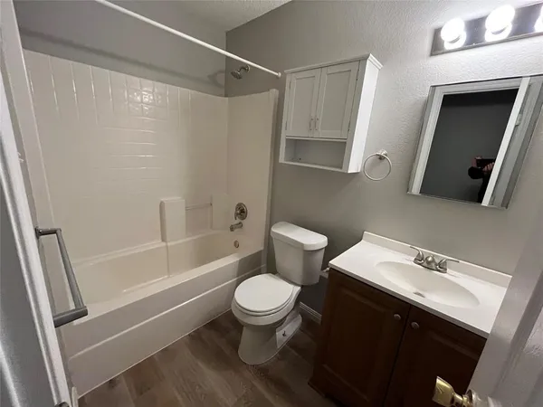 a white toilet sitting next to a bath tub