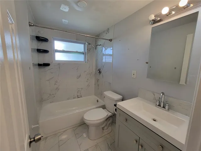 a bathroom with a sink toilet tub and shower