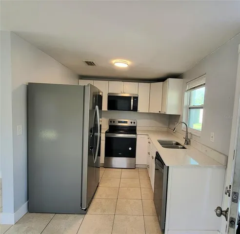 a kitchen with stainless steel appliances granite countertop a refrigerator and a sink