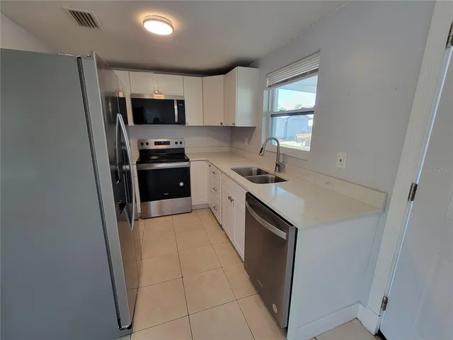 a kitchen with stainless steel appliances a sink stove and refrigerator
