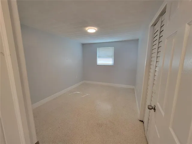 a view of a small space with wooden floor and a window