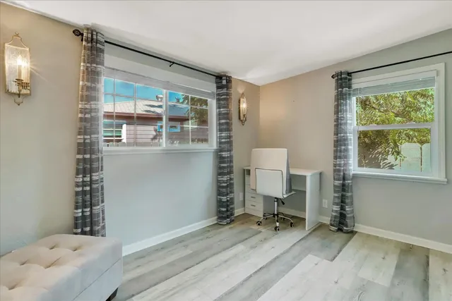 a view of a hallway with wooden floor and a workspace