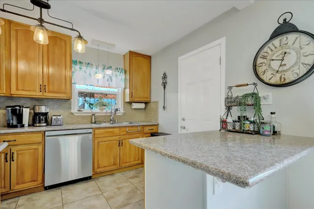 a kitchen with granite countertop a sink a stove and cabinets