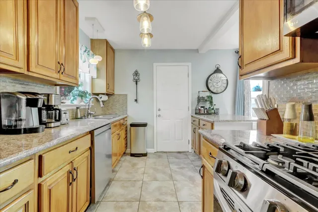 a living room with kitchen island furniture a chandelier and a large window