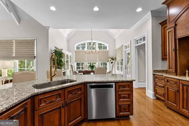 a spacious bedroom with a bed a dresser and a chandelier