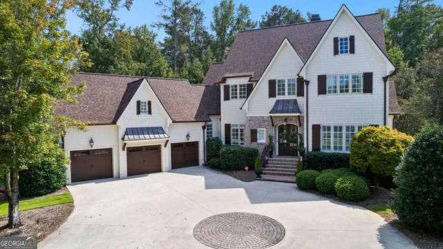 a front view of a house with a garden and trees