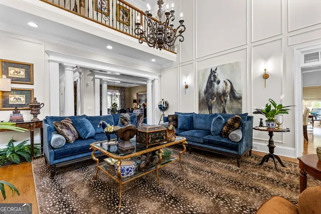 a living room with stainless steel appliances furniture a flat screen tv and a dining table